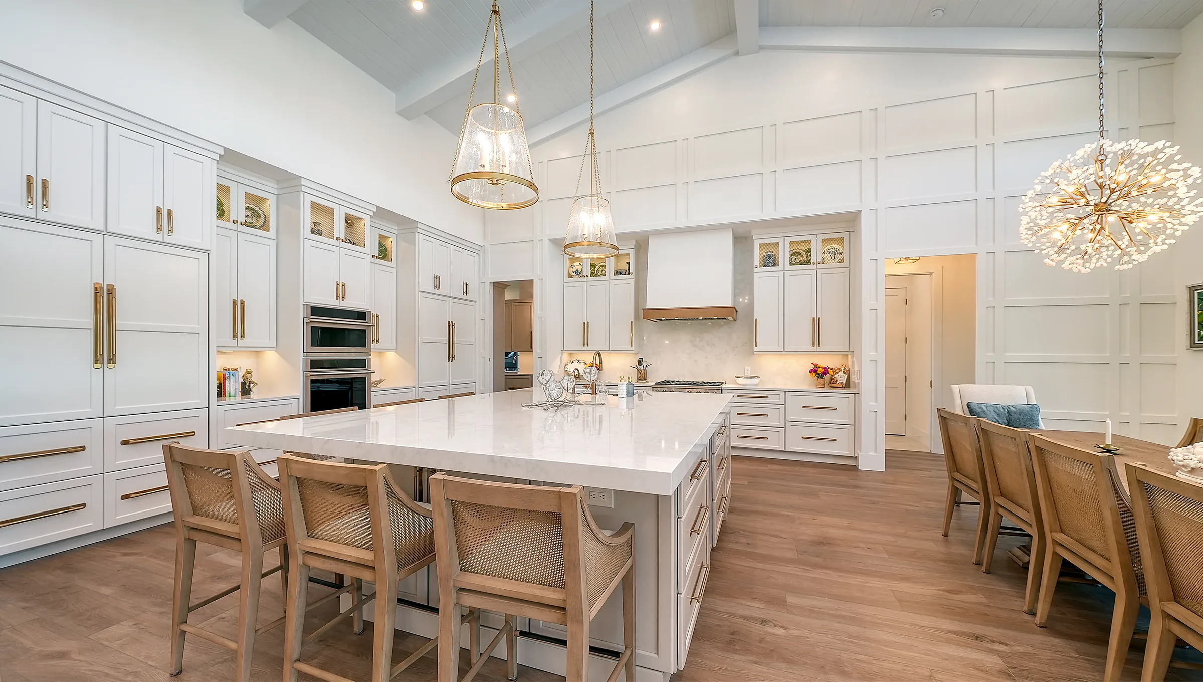 White custom kitchen with large island and crystal chandeliers